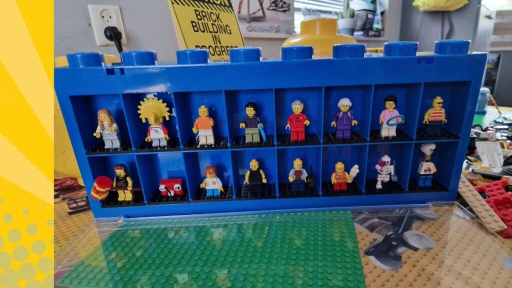Collectie LEGO minifiguren uitgestald in een blauwe LEGO vitrinebak