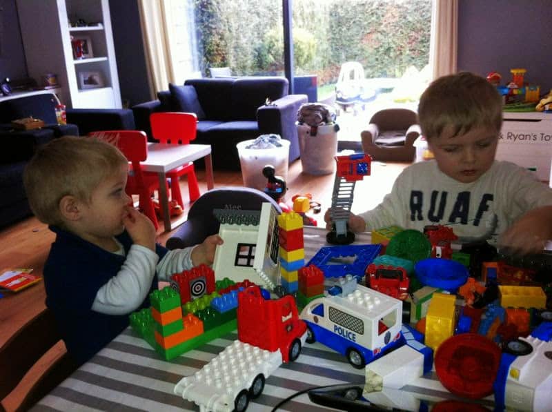 Twee peuters spelen samen met een grote verzameling DUPLO-stenen