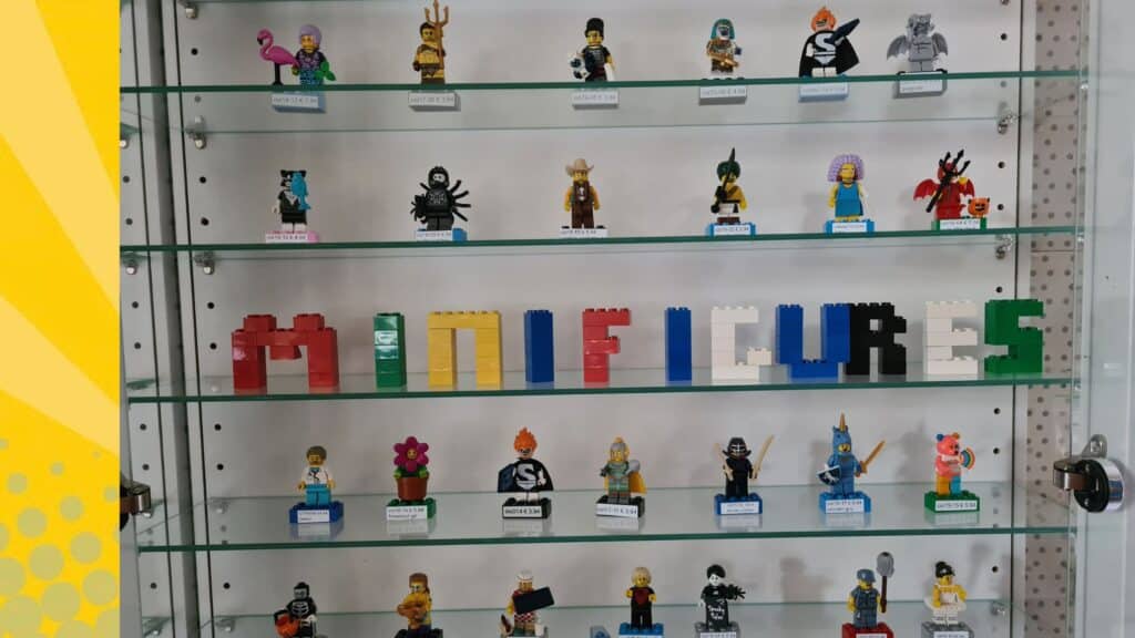 Close-up van LEGO minifiguren op glazen vitrineplank met prijskaartjes