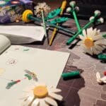 LEGO Botanicals Madeliefjes in aanbouw, losse stenen en instructieboekje op donkere ondergrond