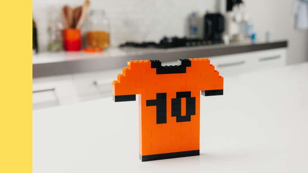 `Oranje LEGO shirt met rugnummer 10, gebouwd van oranje en zwarte LEGO stenen`