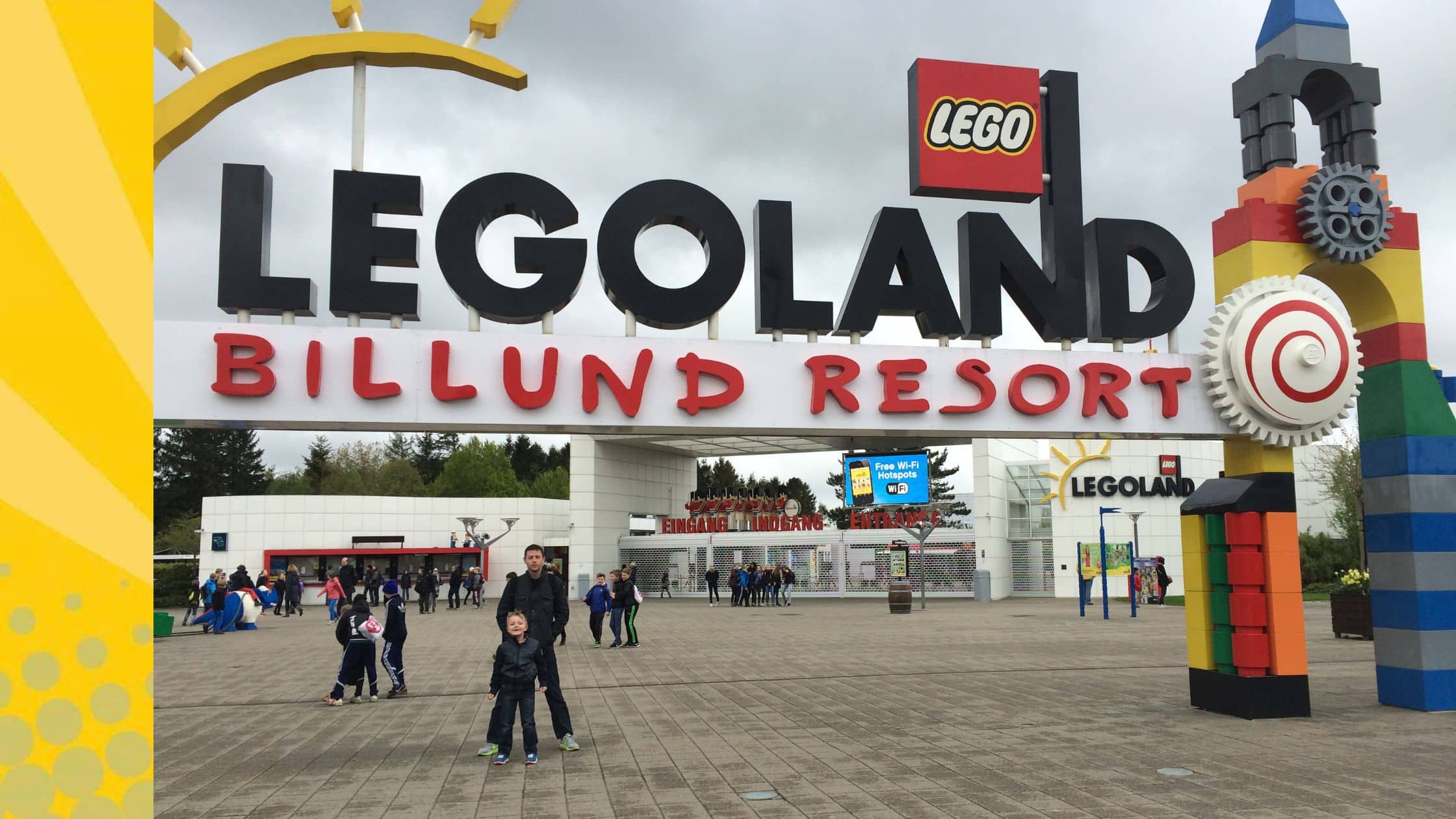 Entree van LEGOLAND Billund Resort in Denemarken met het grote LEGO-bord en een vader met twee kinderen